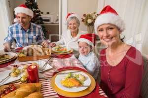 Happy family in santa hat during christmas dinner