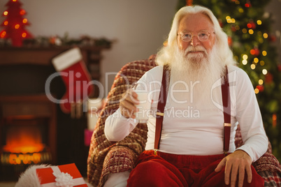 Smiling santa holding a glass of milk