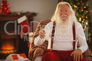 Smiling santa holding a glass of milk