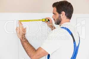 Handyman measuring a wardrobe