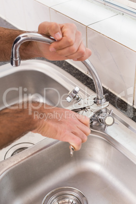 Man fixing tap with pliers