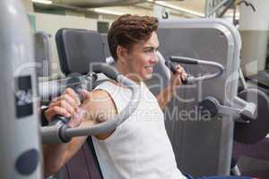 Fit man using weights machine for arms