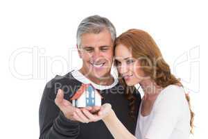 Casual couple holding small house