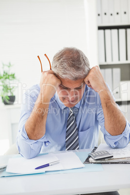 Stressed businessman with head in hands