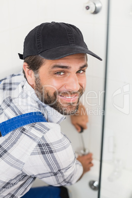 Handyman fixing door with screwdriver