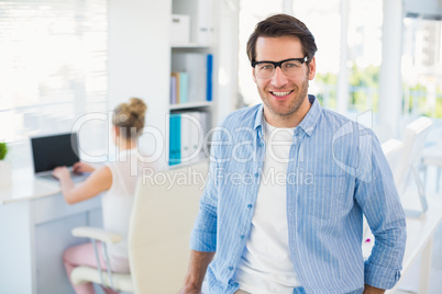 Portrait of smiling photo editor wearing reading glasses