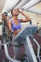 Fit woman working out on the cross trainer