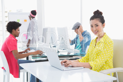 Young creative woman using laptop at desk