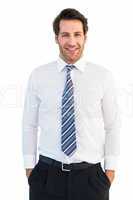 Smiling businessman standing with hands in pockets