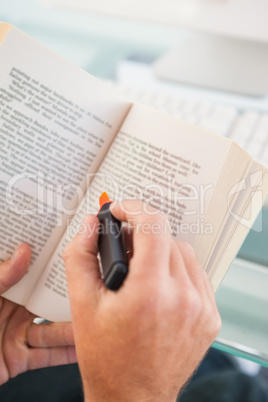 Man reading a booking and highlighting sentences