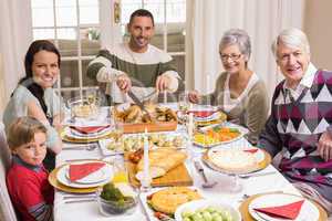 Man carving roast turkey during christmas dinner