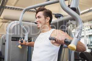 Fit man using weights machine for arms