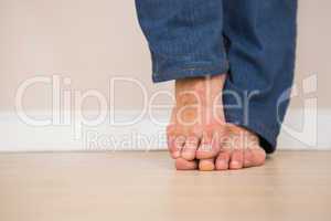 Mans bare feet on wooden floor