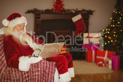 Santa using laptop on the couch at christmas