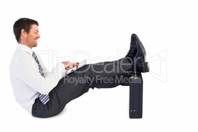 Businessman with feet up on briefcase