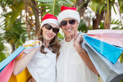 Festive couple holding shopping bags