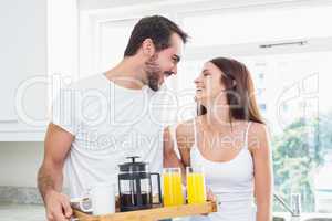 Young couple with breakfast on tray