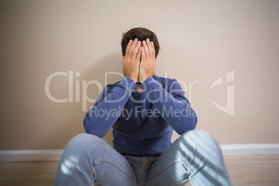 Depressed man sitting on floor