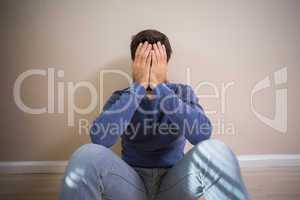 Depressed man sitting on floor