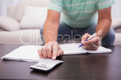 Man working out his finances on the couch