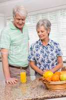 Senior couple looking at glass of orange juice