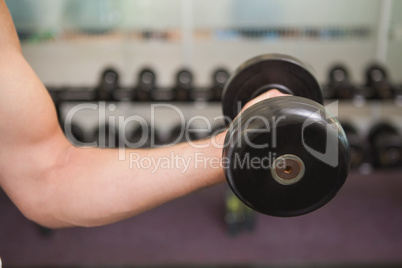 Fit man lifting heavy black dumbbell