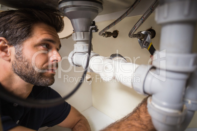 Plumber fixing under the sink