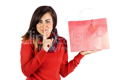 Brunette holding gift bag and keeping a secret