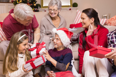 Multi generation family exchanging presents on sofa