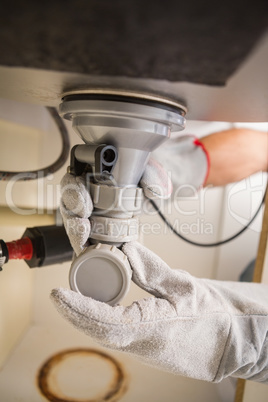 Plumber fixing under the sink