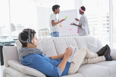 Young creative man using laptop on couch