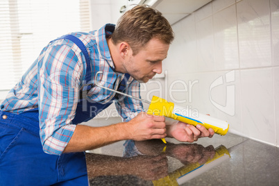 Plumber putting filling in between tiles