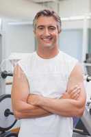 Fit man smiling at camera in fitness studio