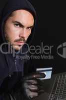 Hacker shopping online with laptop