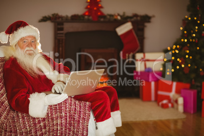 Santa using laptop on the couch at christmas