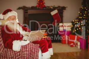 Santa using laptop on the couch at christmas