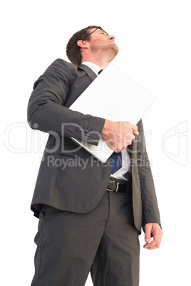 Businessman looking up holding laptop