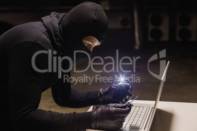 Robber shopping online while making light with his phone