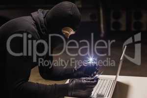 Robber shopping online while making light with his phone