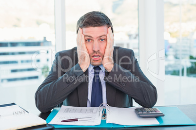 Stressed businessman with head in hands