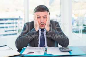 Stressed businessman with head in hands