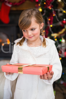 Portrait of a smiling little girl holding a wrapped gift