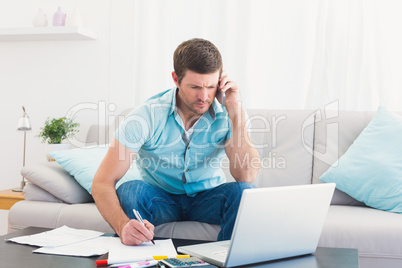 Serious man paying his bills on laptop