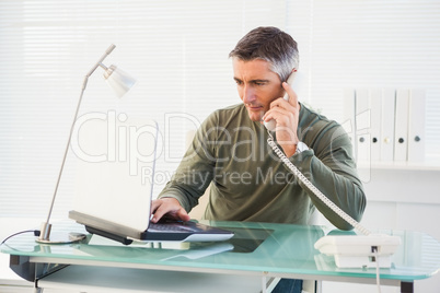 Man on the phone and using laptop