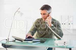 Man on the phone and using laptop
