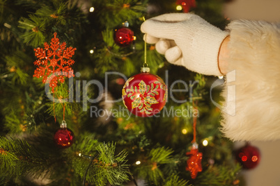 Hand of santa hanging a bauble