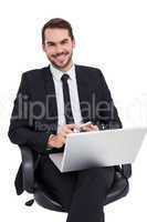 Happy businessman with laptop using smartphone