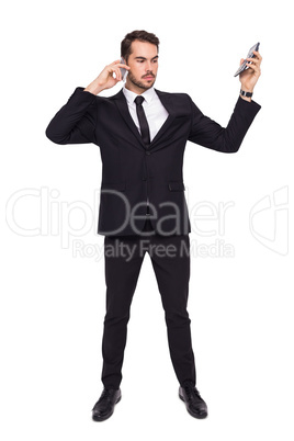 Businessman on the phone holding calculator