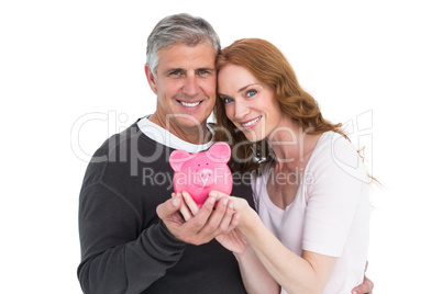 Casual couple showing their piggy bank