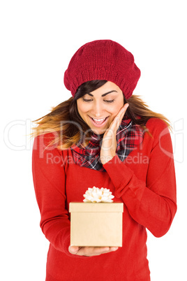 Surprised brunette holding a gift